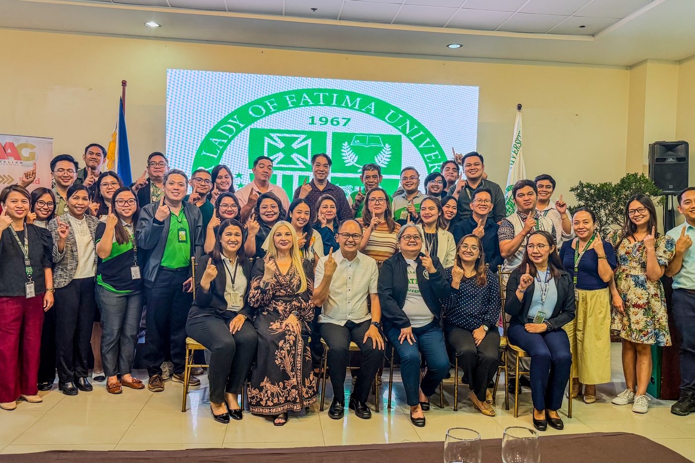 Workshop participants and facilitators gathered for a group photograph in front of the university seal